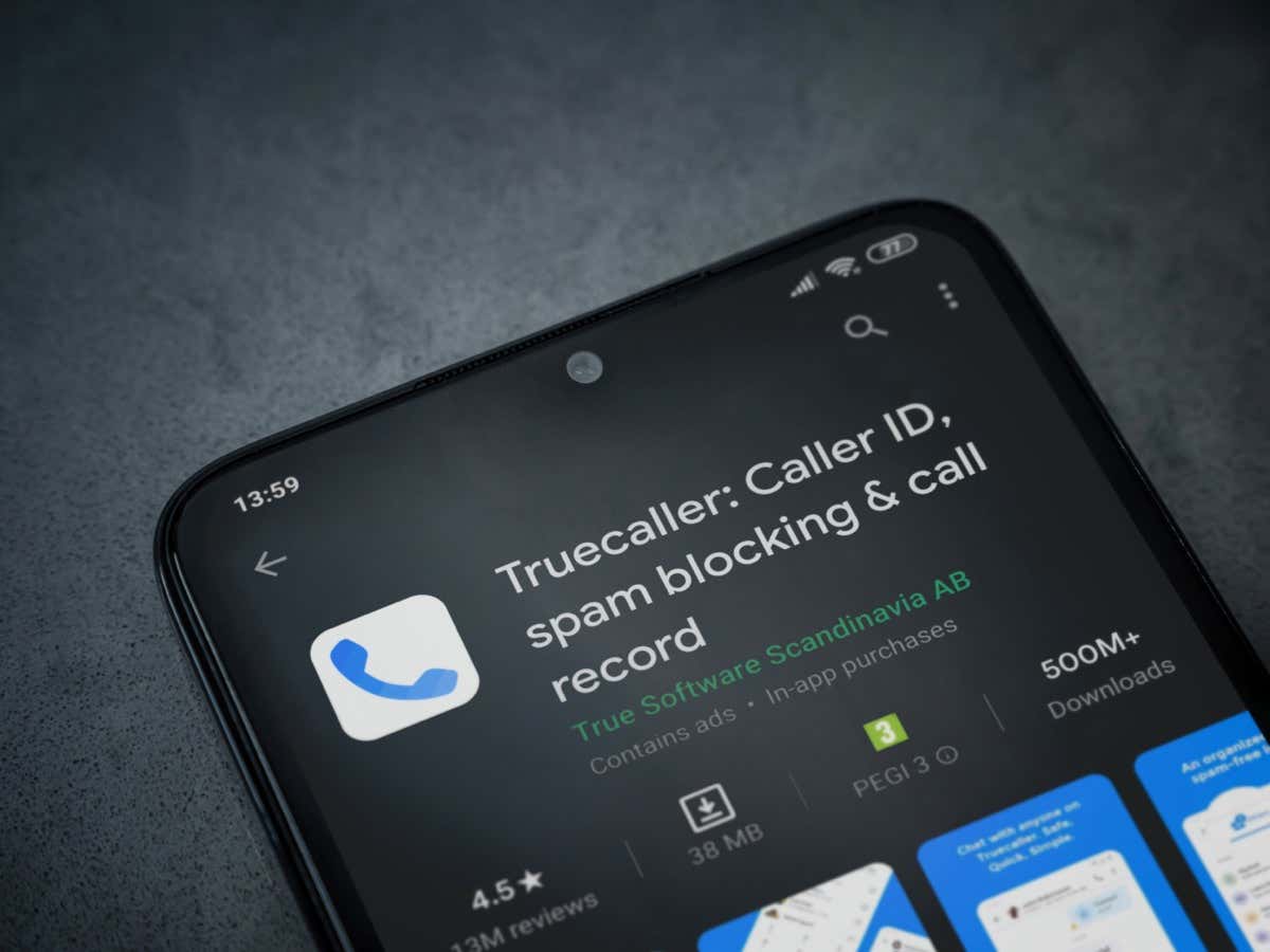 Trang cửa hàng chơi ứng dụng Truecaller trên màn hình điện thoại thông minh di động màu đen trên nền đá cẩm thạch sẫm màu - Mẹo kỹ thuật trực tuyến Trang Truecaller trong cửa hàng ứng dụng