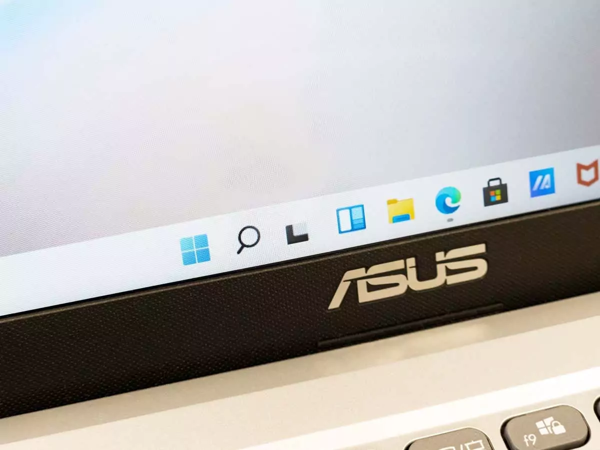 Hệ điều hành Microsoft Windows 11 trên máy tính xách tay Asus, cận cảnh thanh tác vụ menu bắt đầu, không có ai. Giao diện người dùng phiên bản hệ điều hành Win 11 mới, khái niệm nâng cấp hệ thống - Help Desk Geek Cách ẩn thanh Taskbar trên Windows 11 ảnh 1