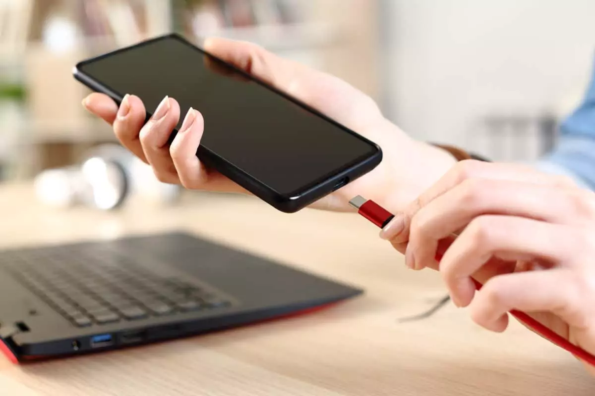 Người phụ nữ dùng tay cắm sạc pin điện thoại - Help Desk Geek Cách khắc phục thiết bị ADB không hiển thị trong Windows 11 hình 1