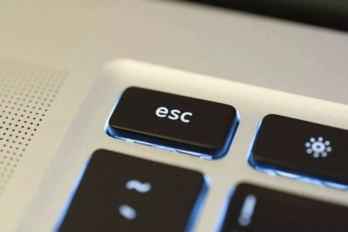 cách thoát-toàn màn hình trong windows-11-3 được nén - Help Desk Geek Bàn phím có đèn nền màu đen trên máy tính xách tay màu bạc hiển thị phím ESC.