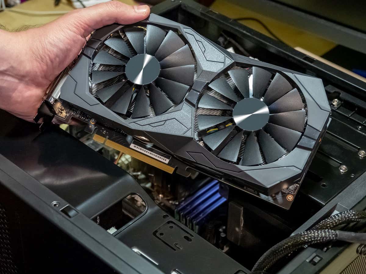 Bàn tay kỹ thuật viên lắp card đồ họa - Help Desk Geek Cách tìm hiểu card đồ họa trong PC Windows 11 của bạn hình ảnh 1