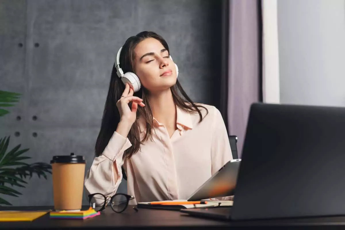Cô gái đeo tai nghe thưởng thức âm nhạc trước máy tính xách tay. Chất lượng âm thanh tuyệt vời và thiết kế của tai nghe không dây. Nữ phát trực tuyến nội dung âm nhạc và giải trí thư giãn từ internet. - Mẹo công nghệ trực tuyến Đường cong Harman là gì (và nó cải thiện chất lượng âm thanh tai nghe như thế nào)? hình ảnh