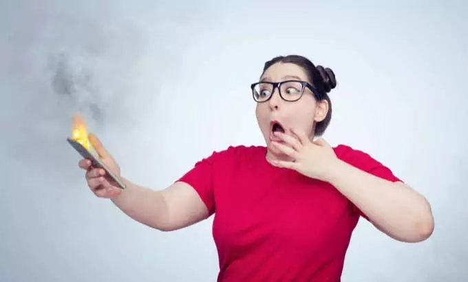 Chiếc điện thoại thông minh phát nổ trên tay cô gái trẻ đeo kính. Tình trạng cháy pin điện thoại. - Mẹo công nghệ trực tuyến Tại sao điện thoại của tôi nóng? 8 thứ khiến điện thoại của bạn quá nóng
